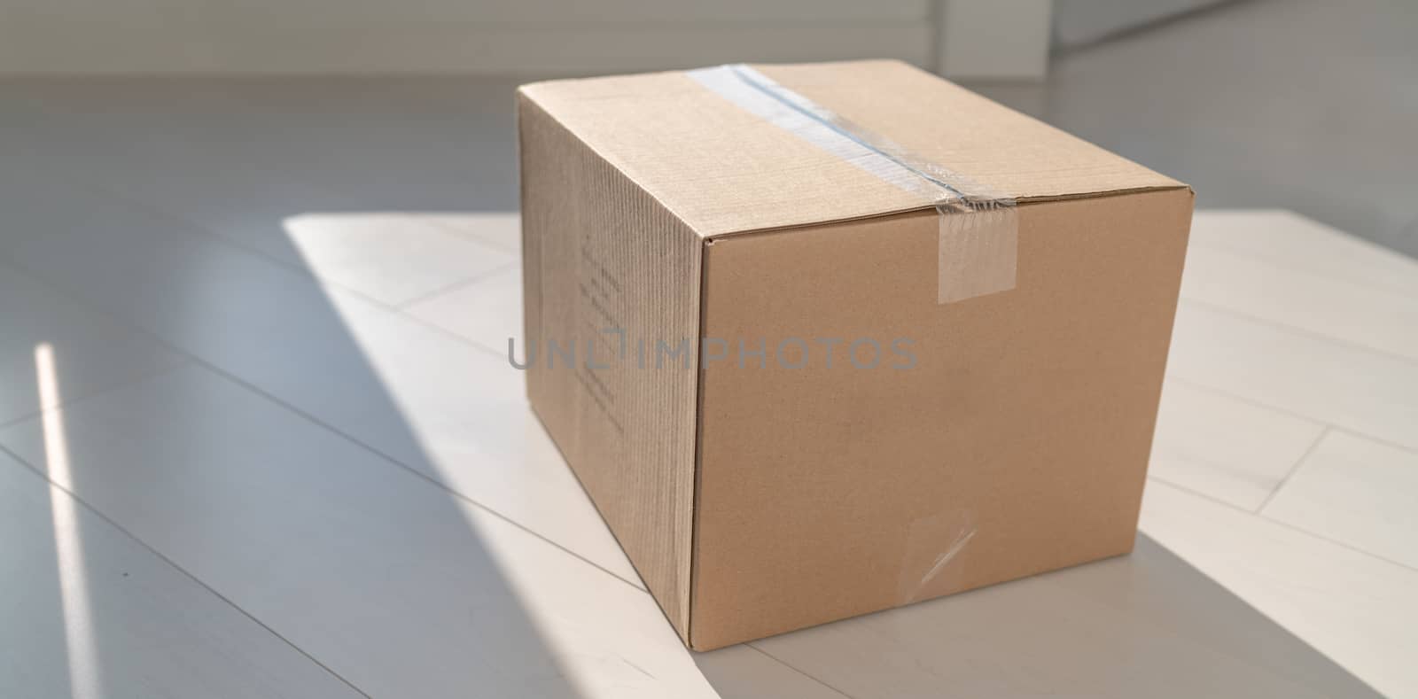 Home delivery cardboard box package delivered at doorstep on floor of entrance door. Parcel shipping for retail online shopping businesses by Maridav