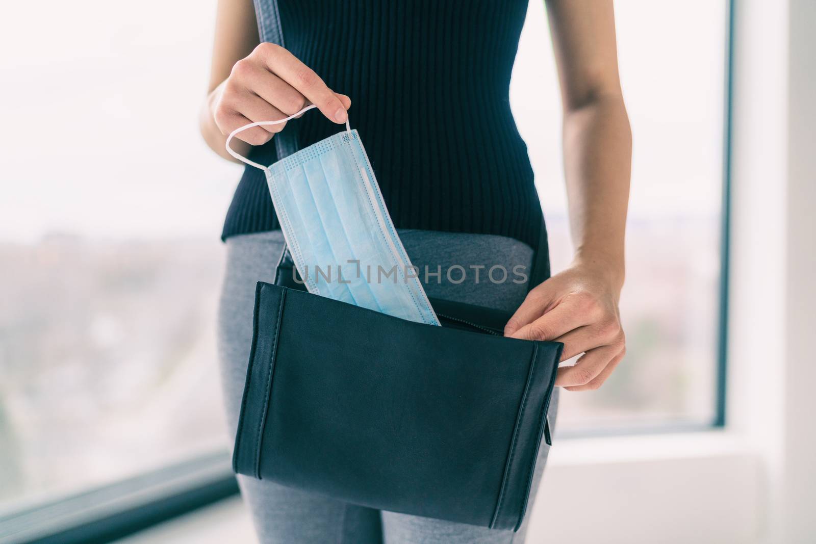 COVID-19 Prevention woman bringing medical mask in her purse for walking outside doing errands in public spaces and store. Coronavirus face masks protection obligatory wear to work.