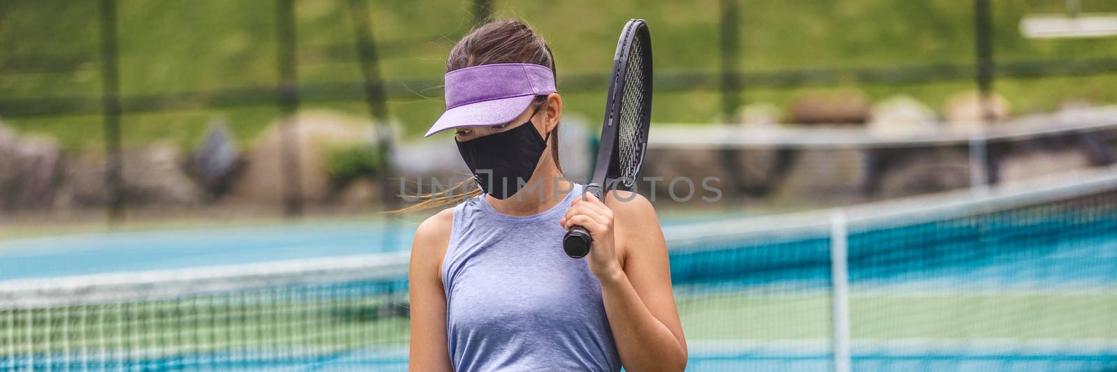 Tennis court reopen after covid-19 confinement. Woman athlete player wearing face mask during game playing oustide on outdoor courts banner panoramic by Maridav