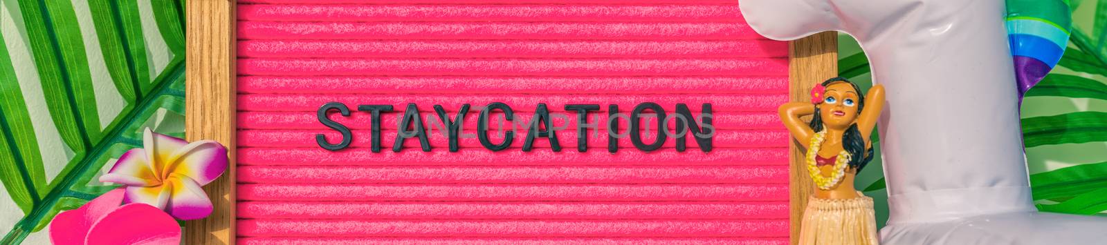 Staycation banner sign for summer vacation plans during COVID-19. Funny pink felt board text for staying home for the holidays. What to do this summer without traveling by Maridav