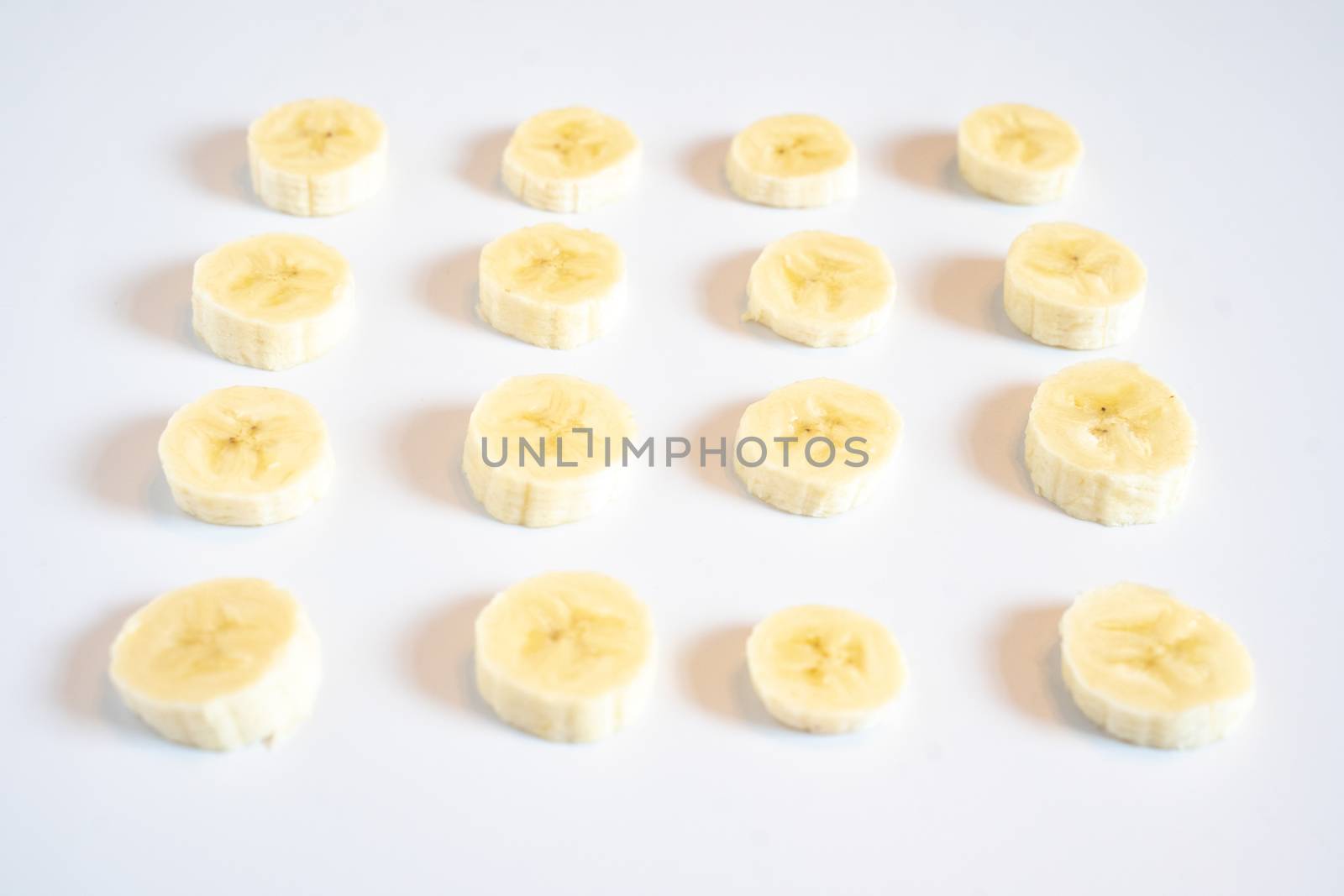 Slices of banana in a square pattern against a plain white background