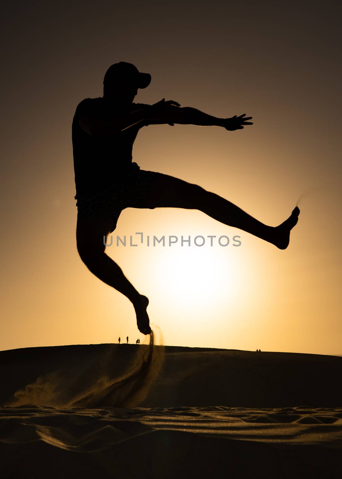 A man jumping in front of a beautiful sunset to create and abstract silhouette