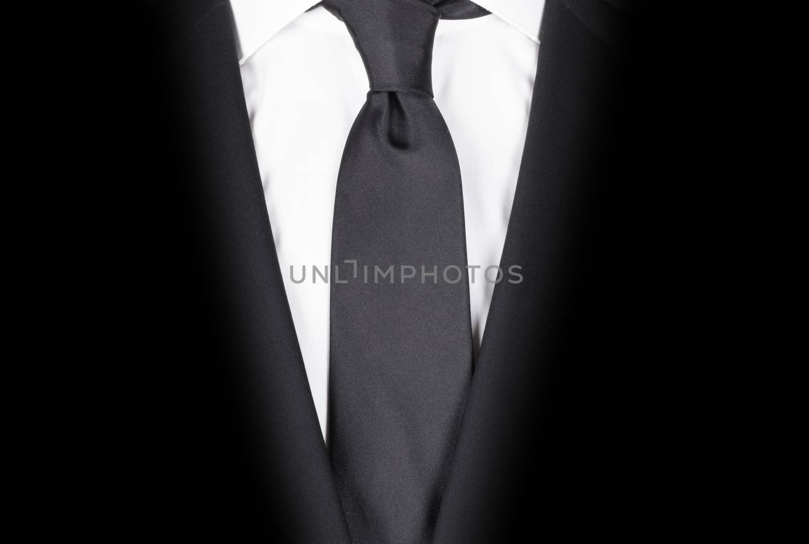 Man in a black suit with black tie, close-up