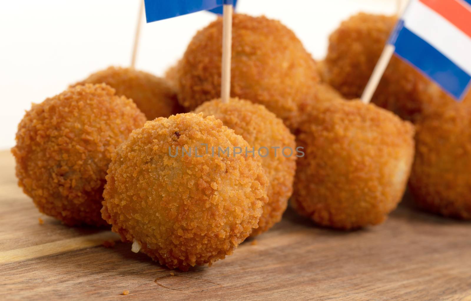 Dutch traditional snack bitterbal on a serving board, dutch flag, isolated