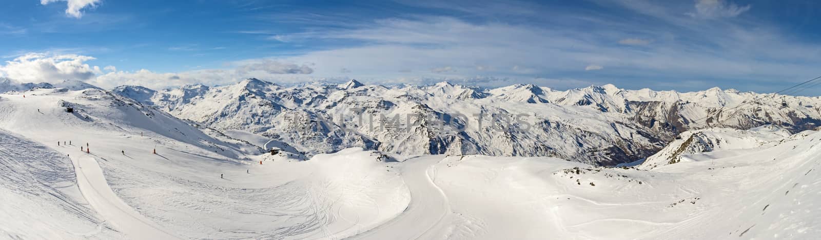 Ski slope piste in winter alpine resort with european alps mountain range in background
