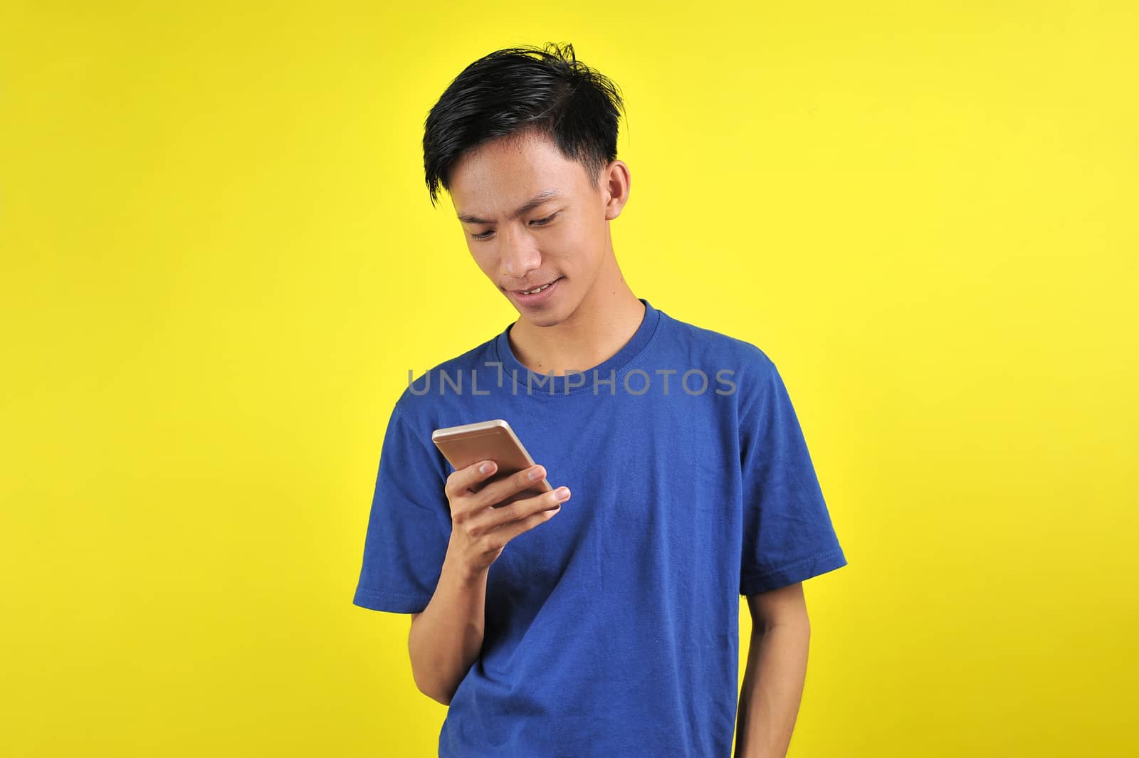 Happy of young good looking Asian man smiling using smartphone by heruan1507