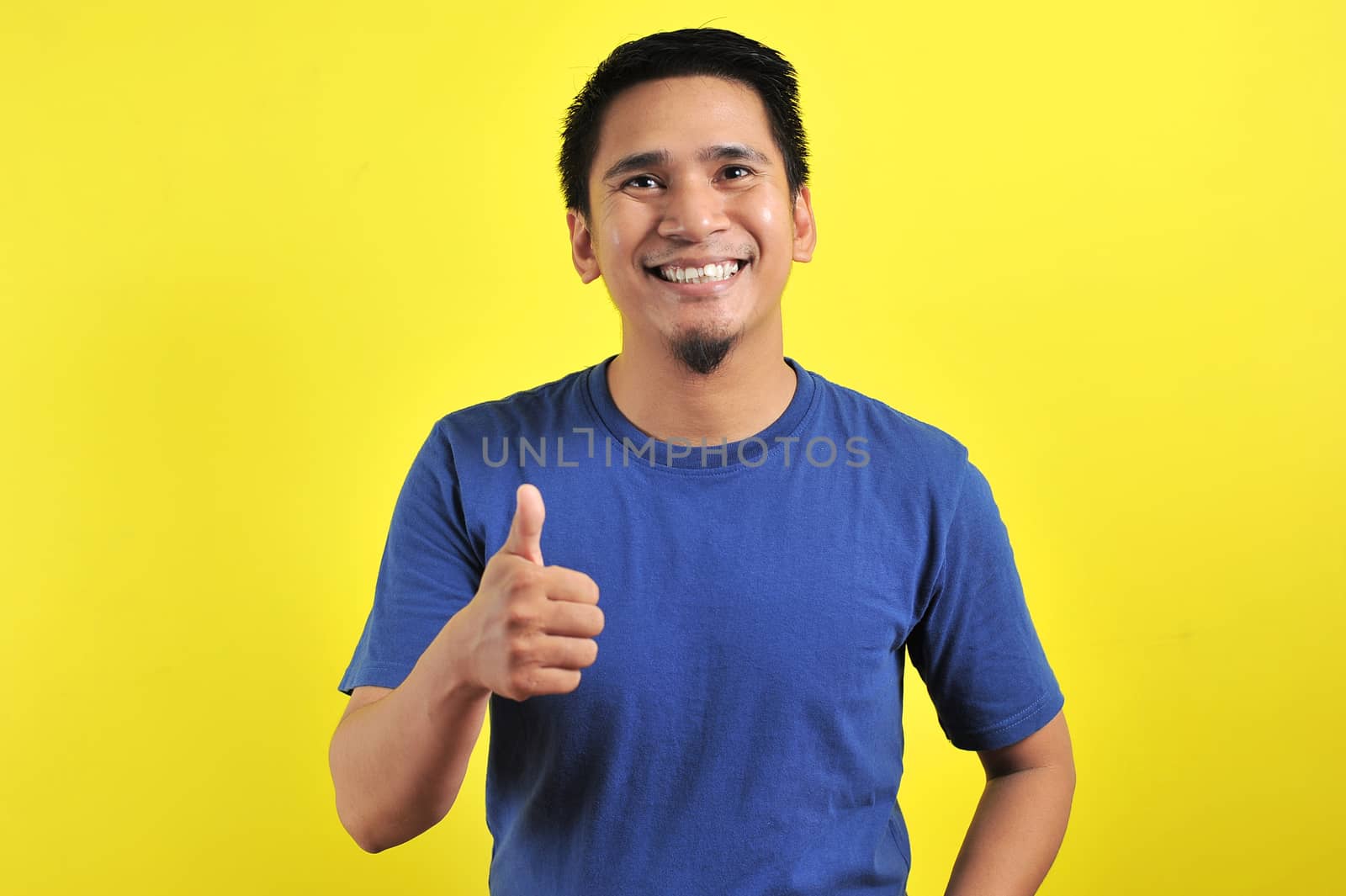 Portrait of young Asian man laughing with showing thumbs up at camera by heruan1507