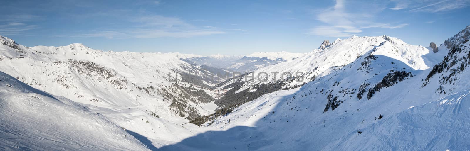 Panoramic view of a snow covered mountain range in the alps looking down valley