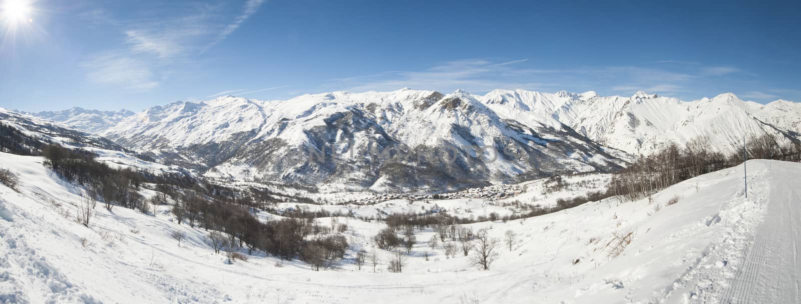 Panoramic view of a snow covered mountain range in the alps looking down valley