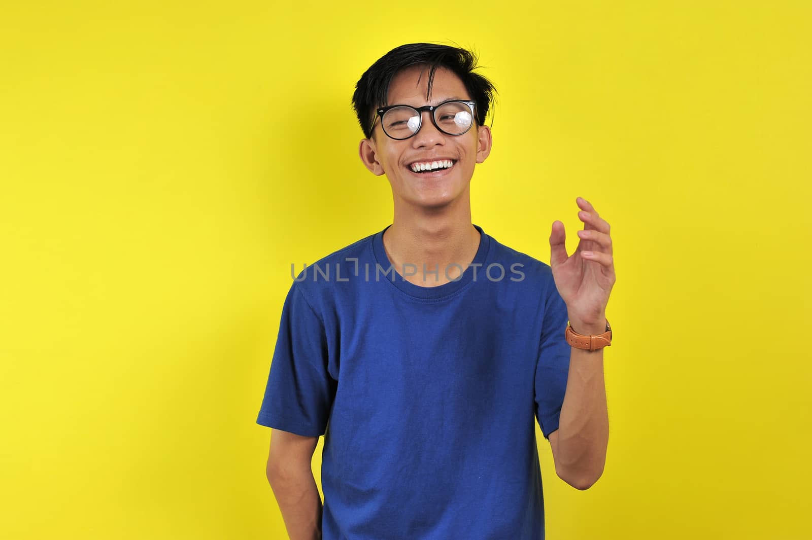 Happy Young Asian man smiling wearing glasses, isolated on yello by heruan1507