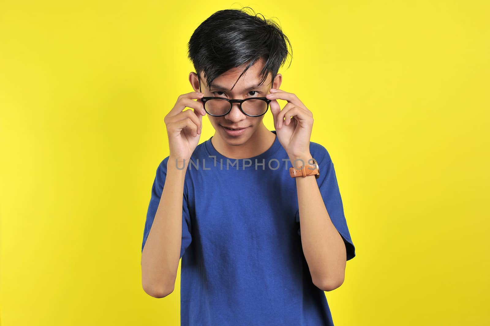 Close up portrait of attractive stylish charming confident, holding eyelets with hands, isolated on yellow background