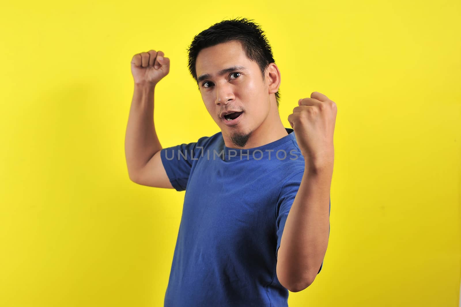 Young asian man happy and excited expressing winning gesture by heruan1507