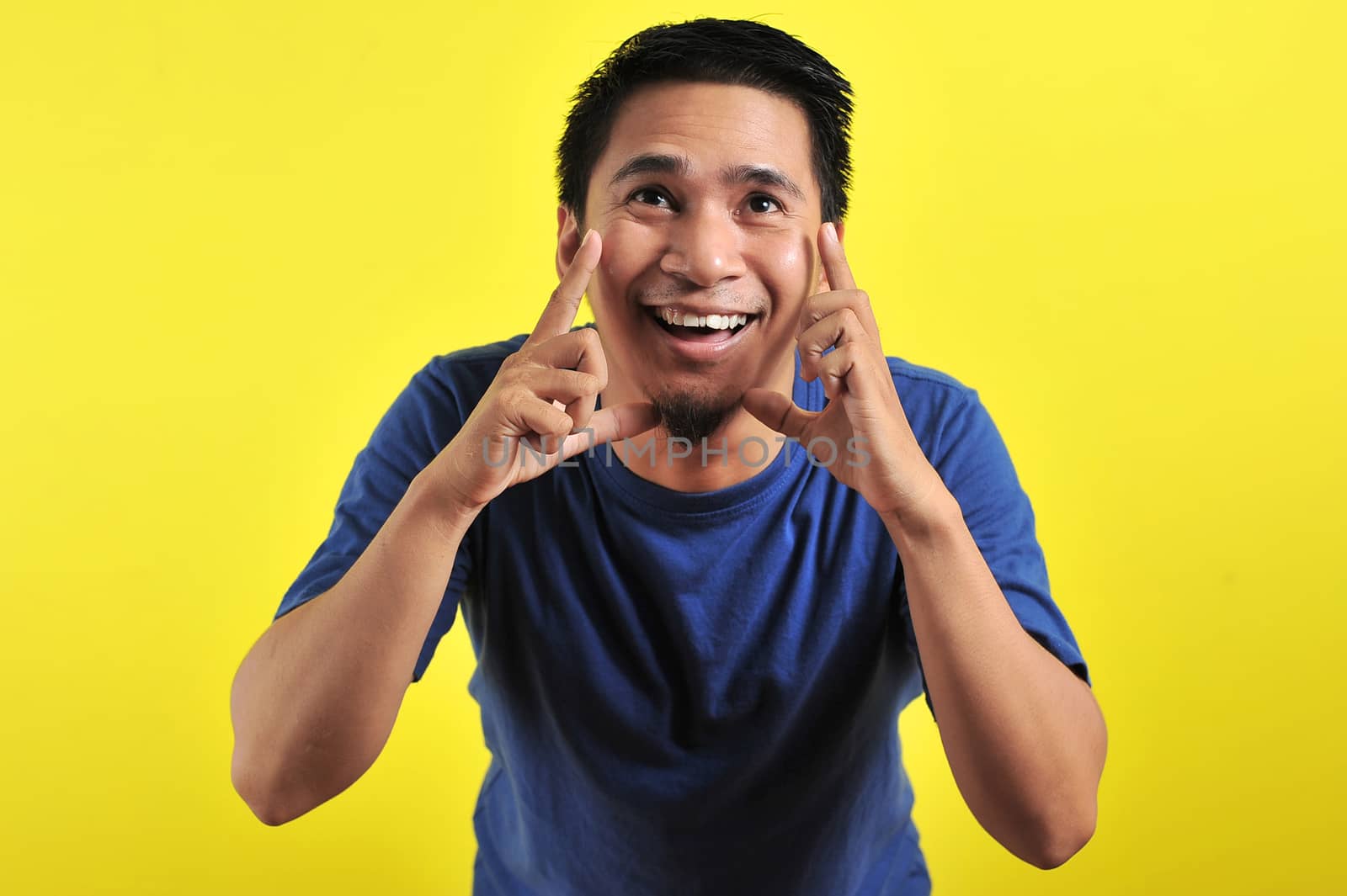 Close up portrait of young man yelling with open mouth, isolated on yellow background