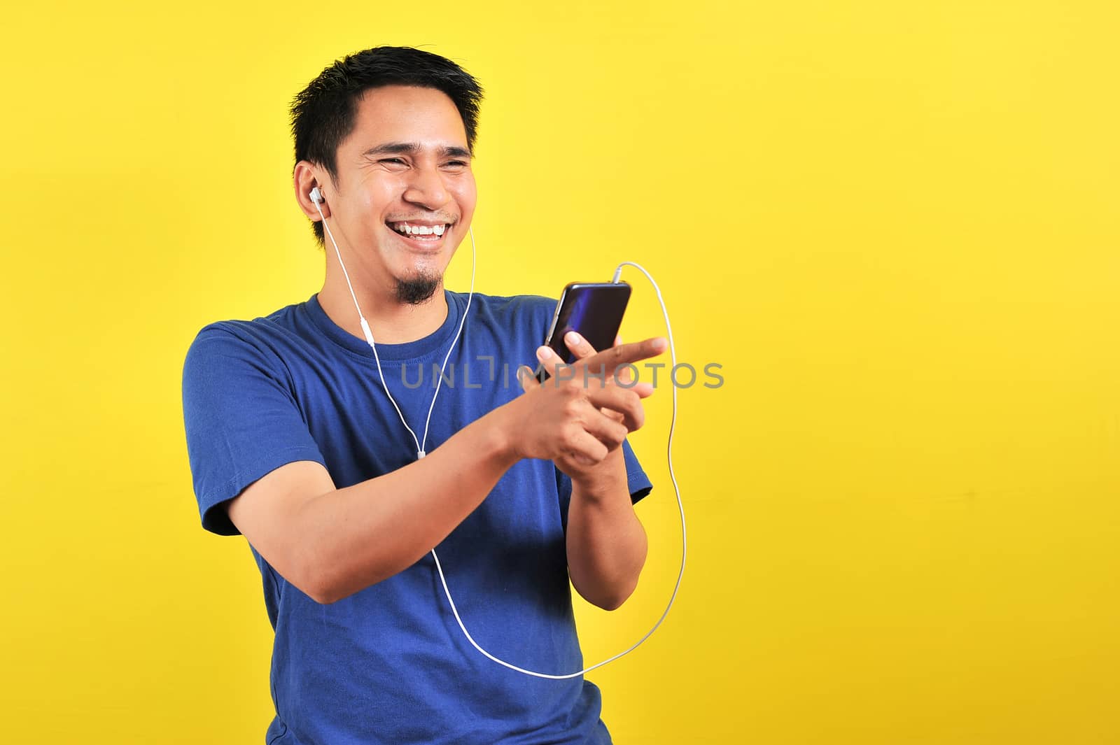 Portrait of excited Asian man laugh happily listening of music by heruan1507