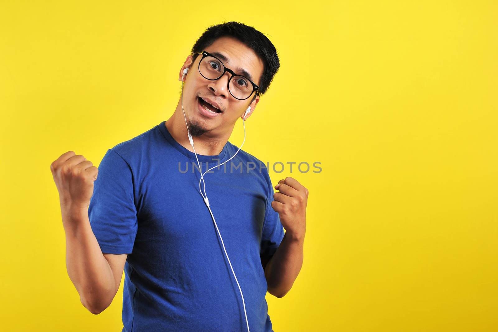 Portrait of excited Asian man laugh happily listening of music by heruan1507