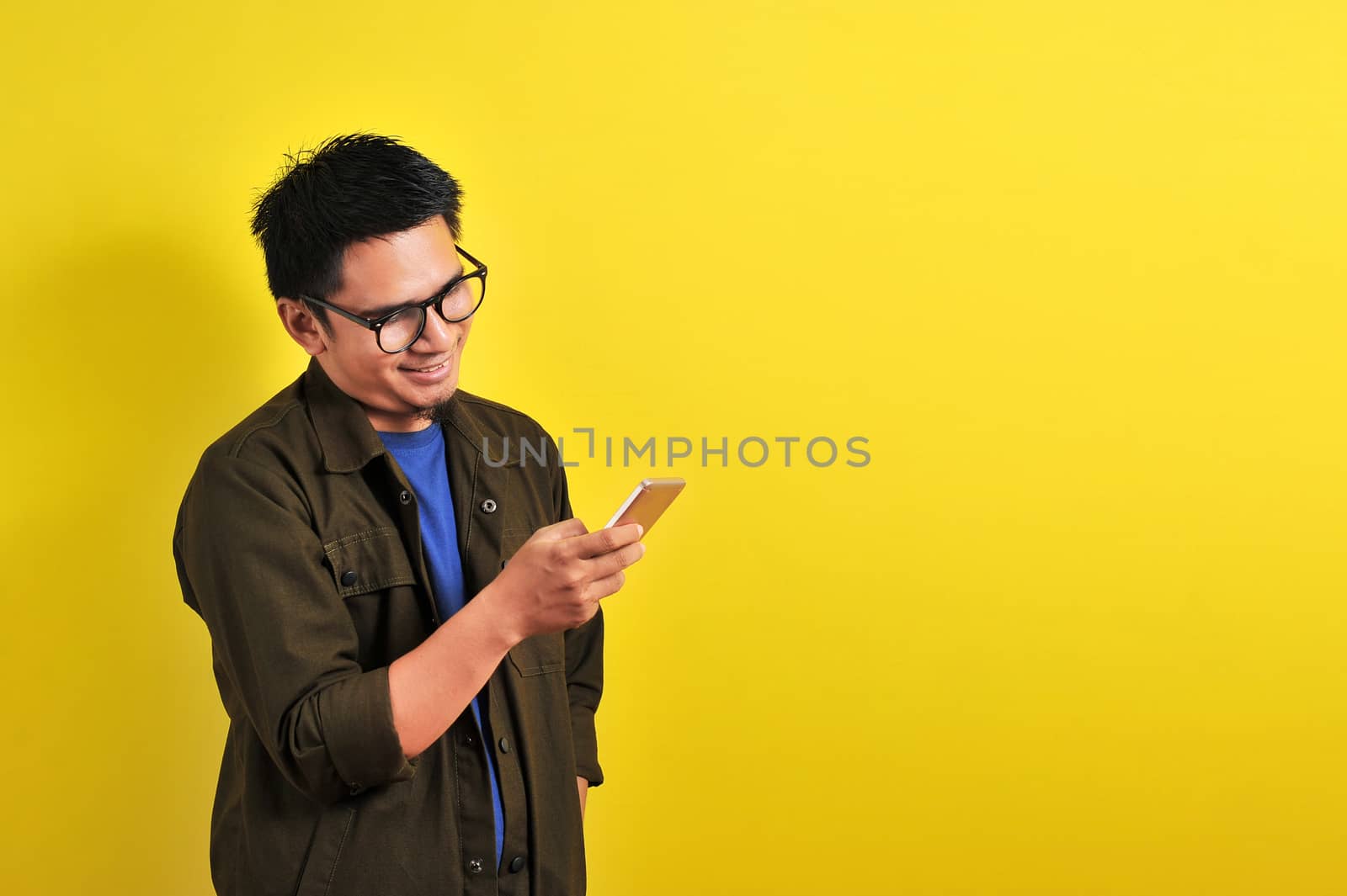 Portrait of happy smiling Asian man using smartphone by heruan1507