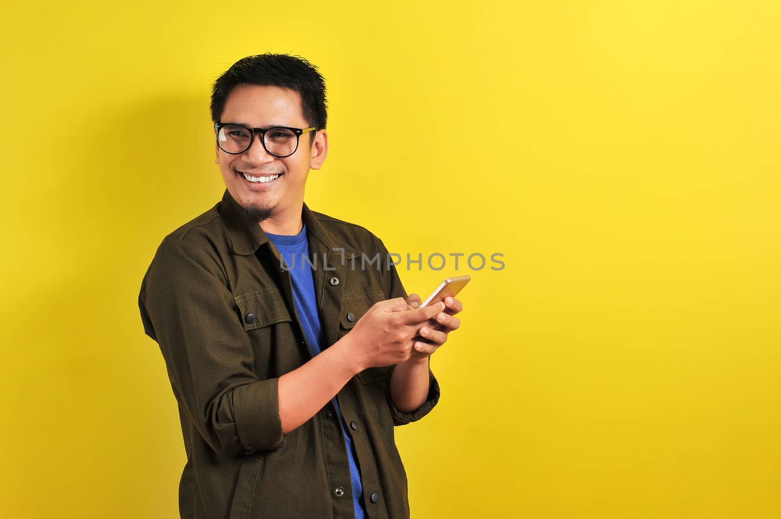 Portrait of happy smiling Asian man using smartphone by heruan1507