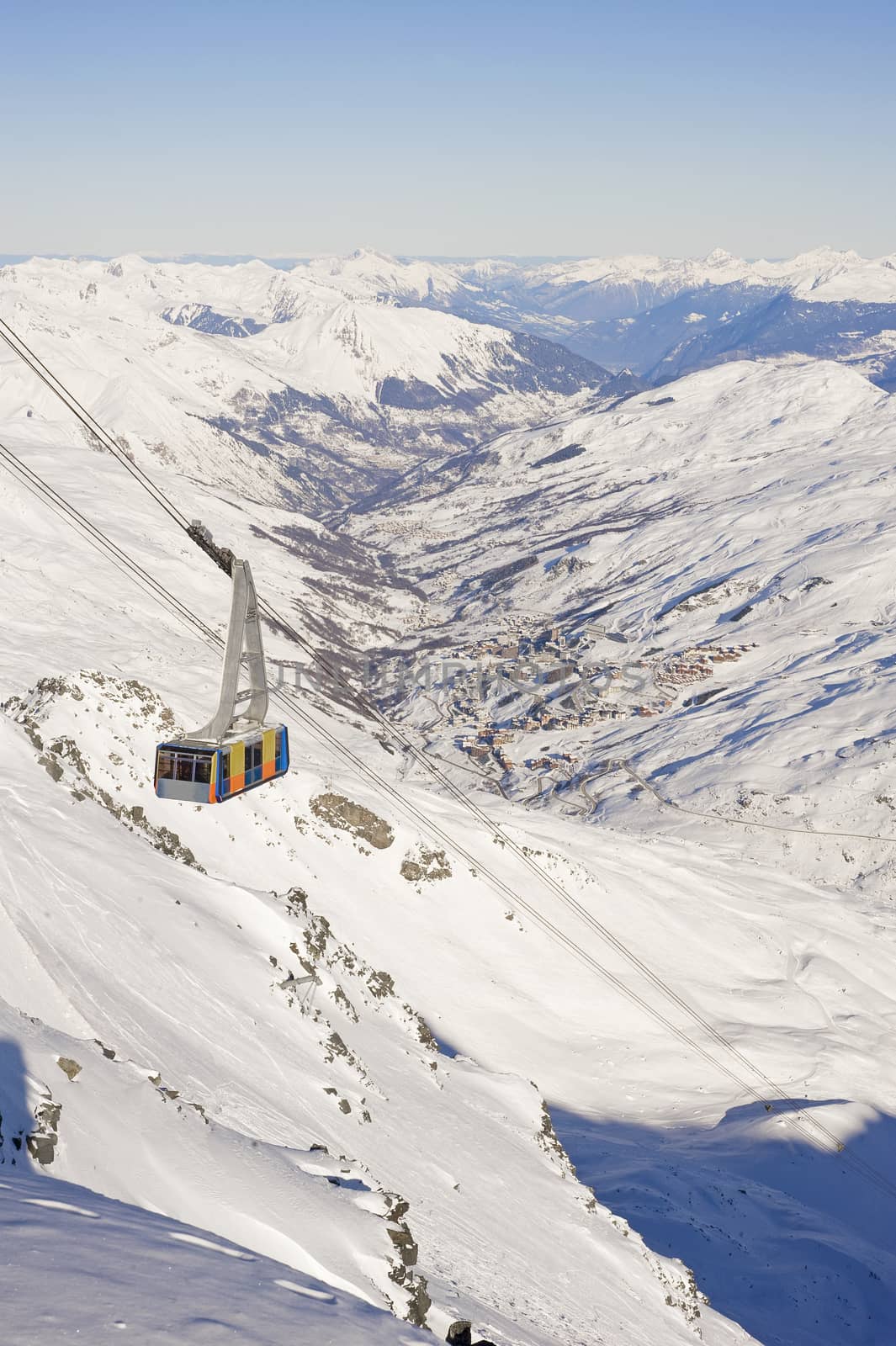 Large cable car ascending a snowy mountain valley