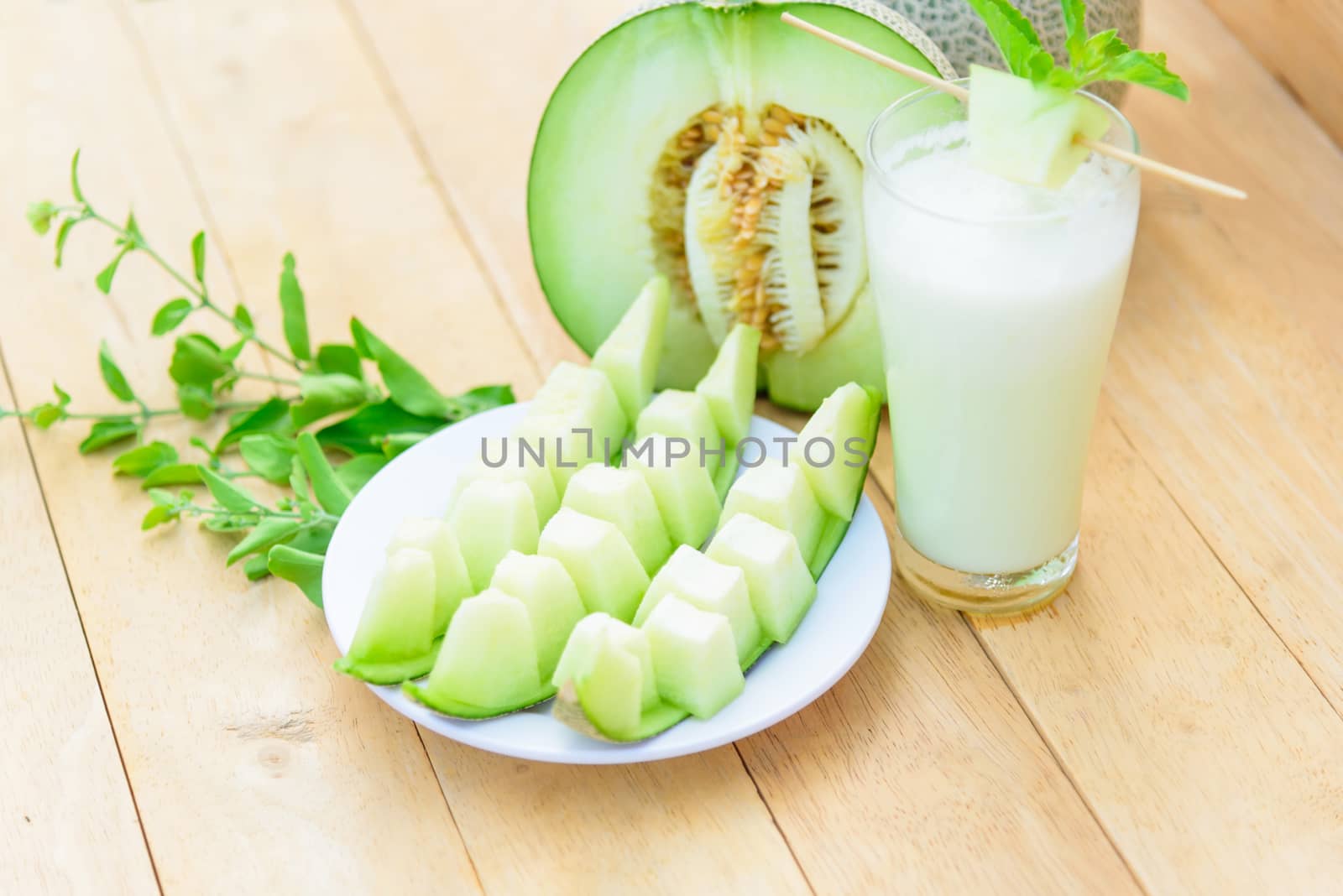 Fresh green melon on wood plate by rukawajung