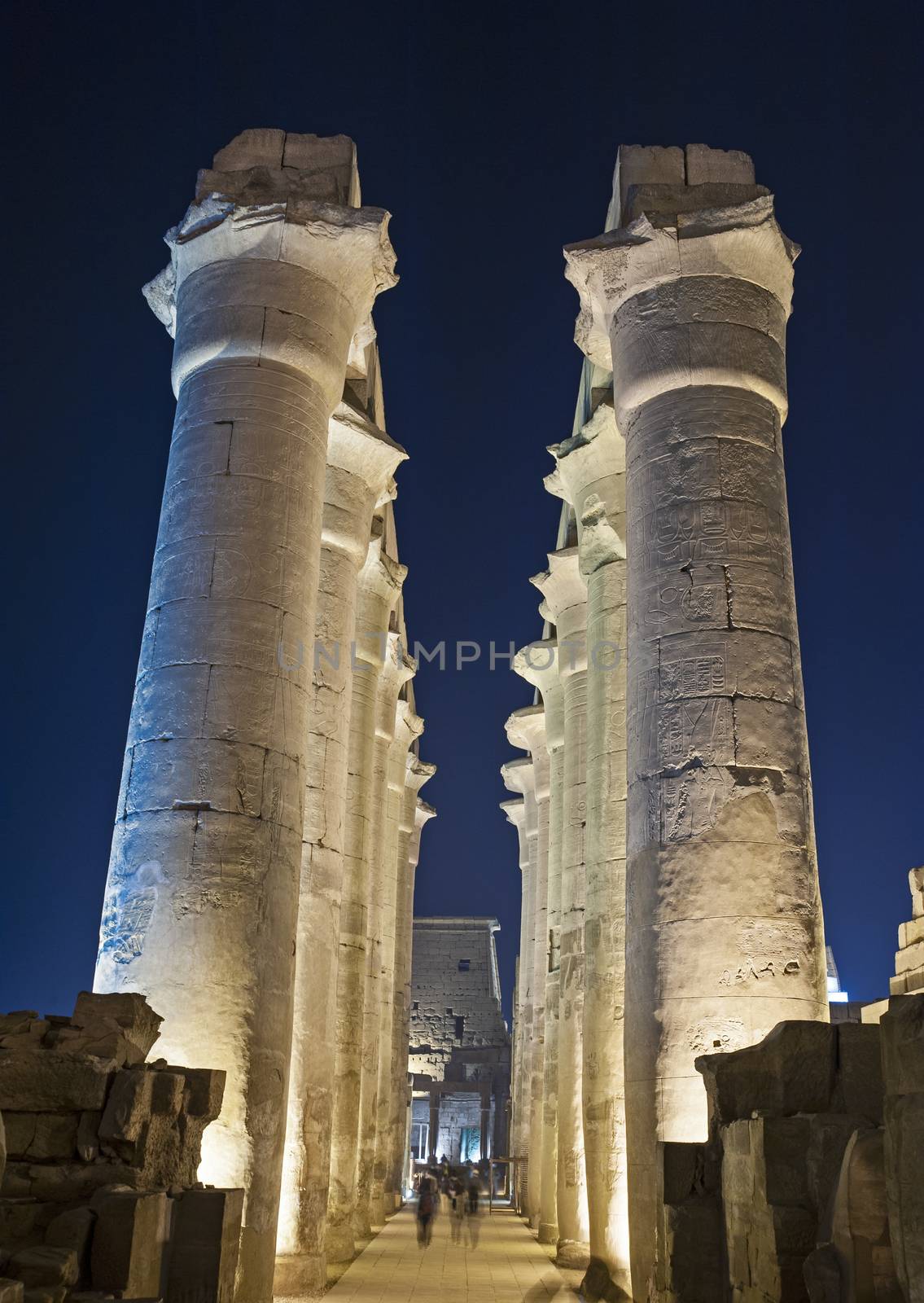 Large columns in hypostyle hall at ancient egyptian Luxor Temple lit up during night