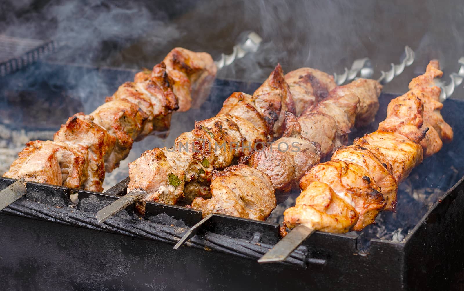 Marinated shashlik or kebab preparing on a barbecue grill over charcoal