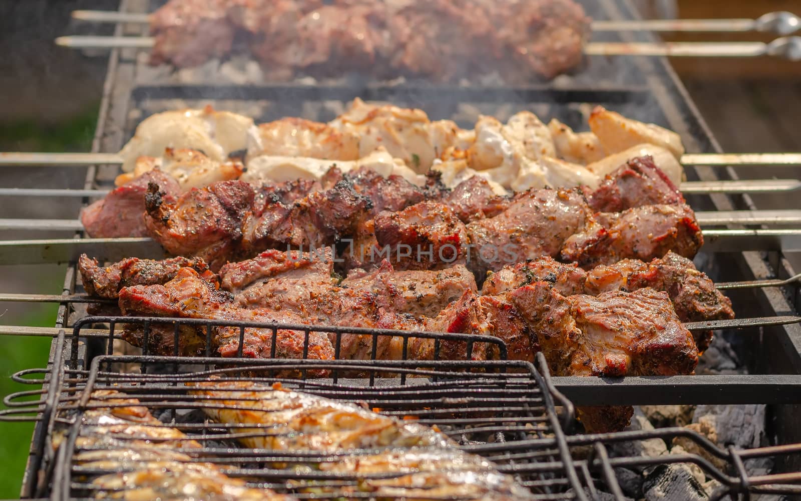 Marinated shashlik or kebab preparing on a barbecue grill over c by bormash