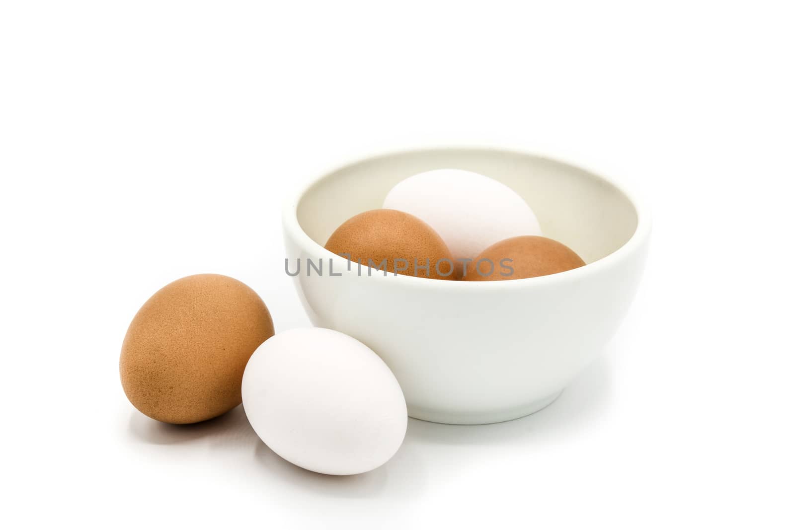 Brown and white eggs in a bowl isolated on white background