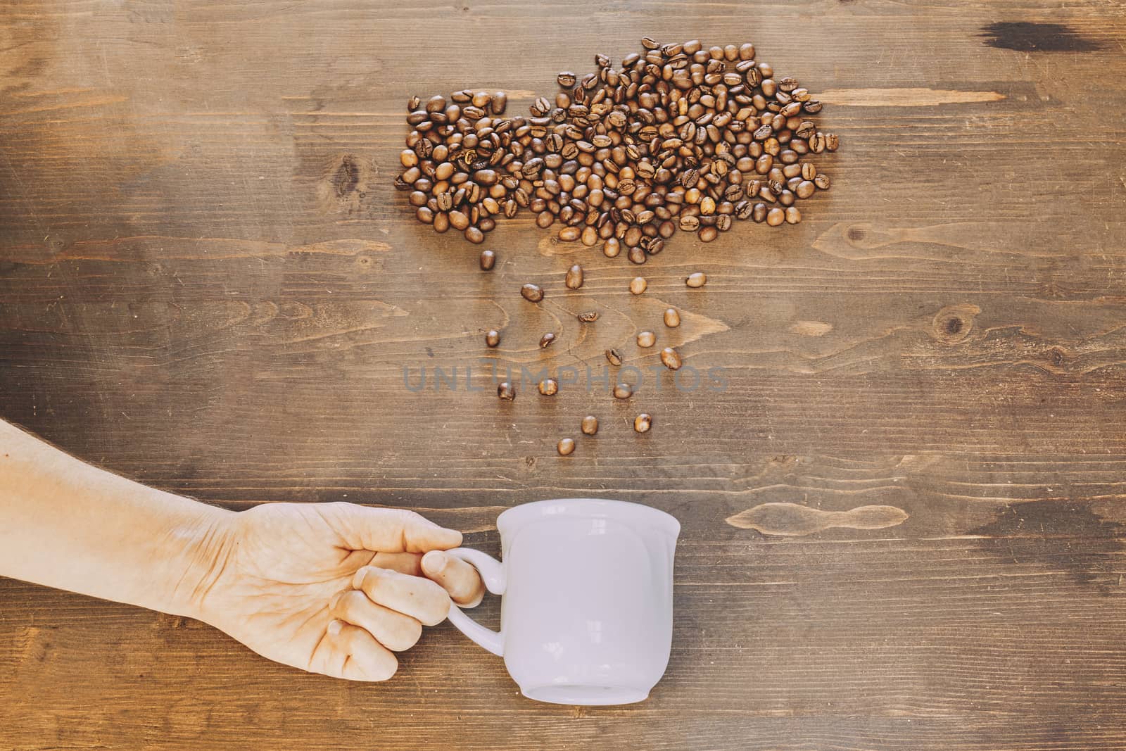 Rain of coffee beans in a white cup by Daniel_Mato