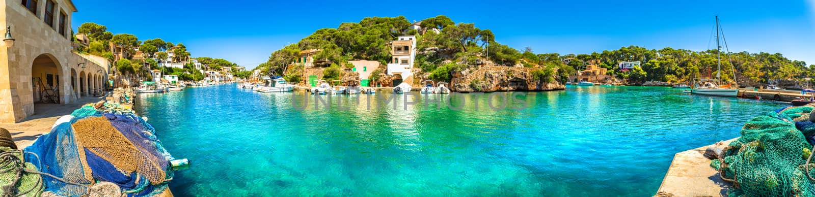 Panoramic view of old fisher village and boats at bay coast of Mallorca island