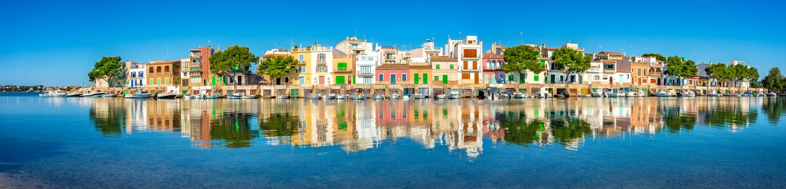 Beautiful panoramic view of waterfront with colorful buildings and boats of old fishing town Portocolom on Mallorca