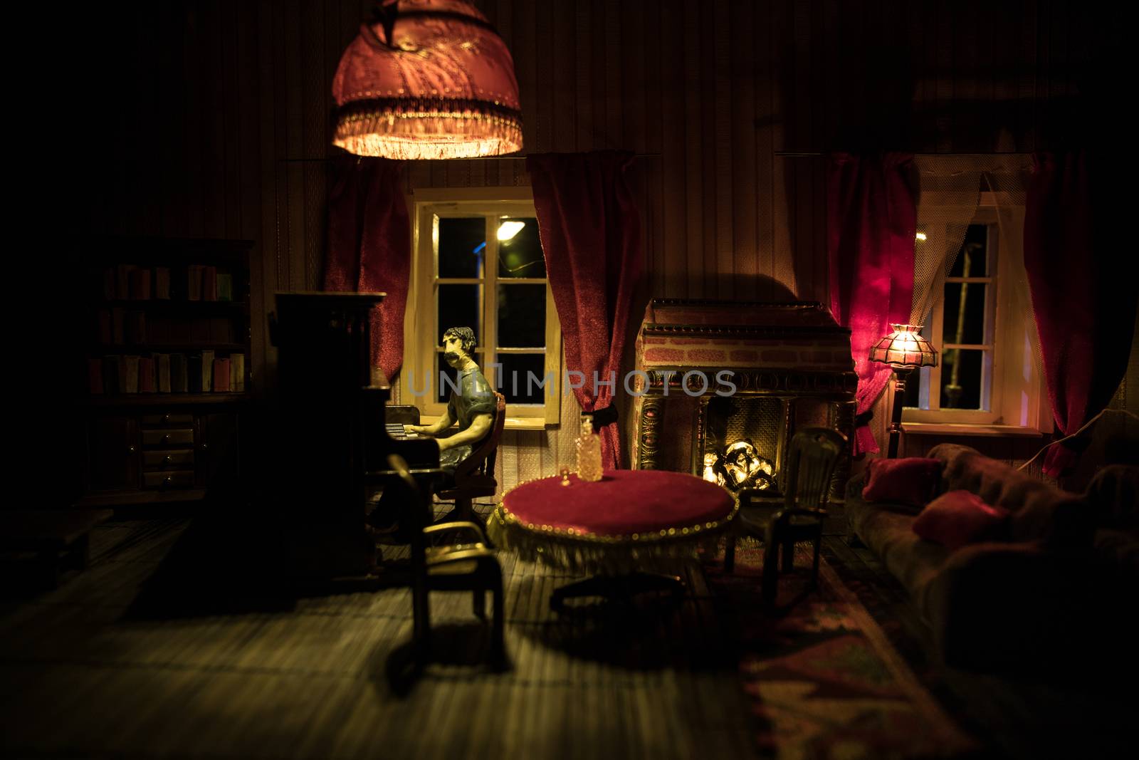 A realistic dollhouse living room with furniture and window at night. Man sitting at the old piano in dark room. Selective focus.