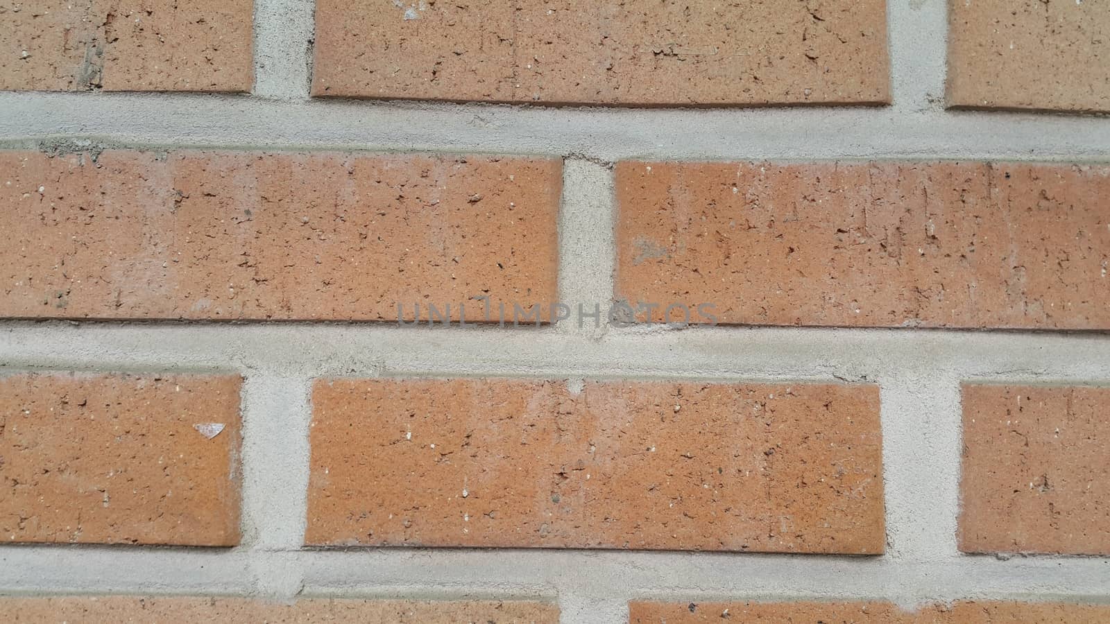 Closeup texture of red brick wall. A background of a weathered old exterior brick wall in the sunshine.