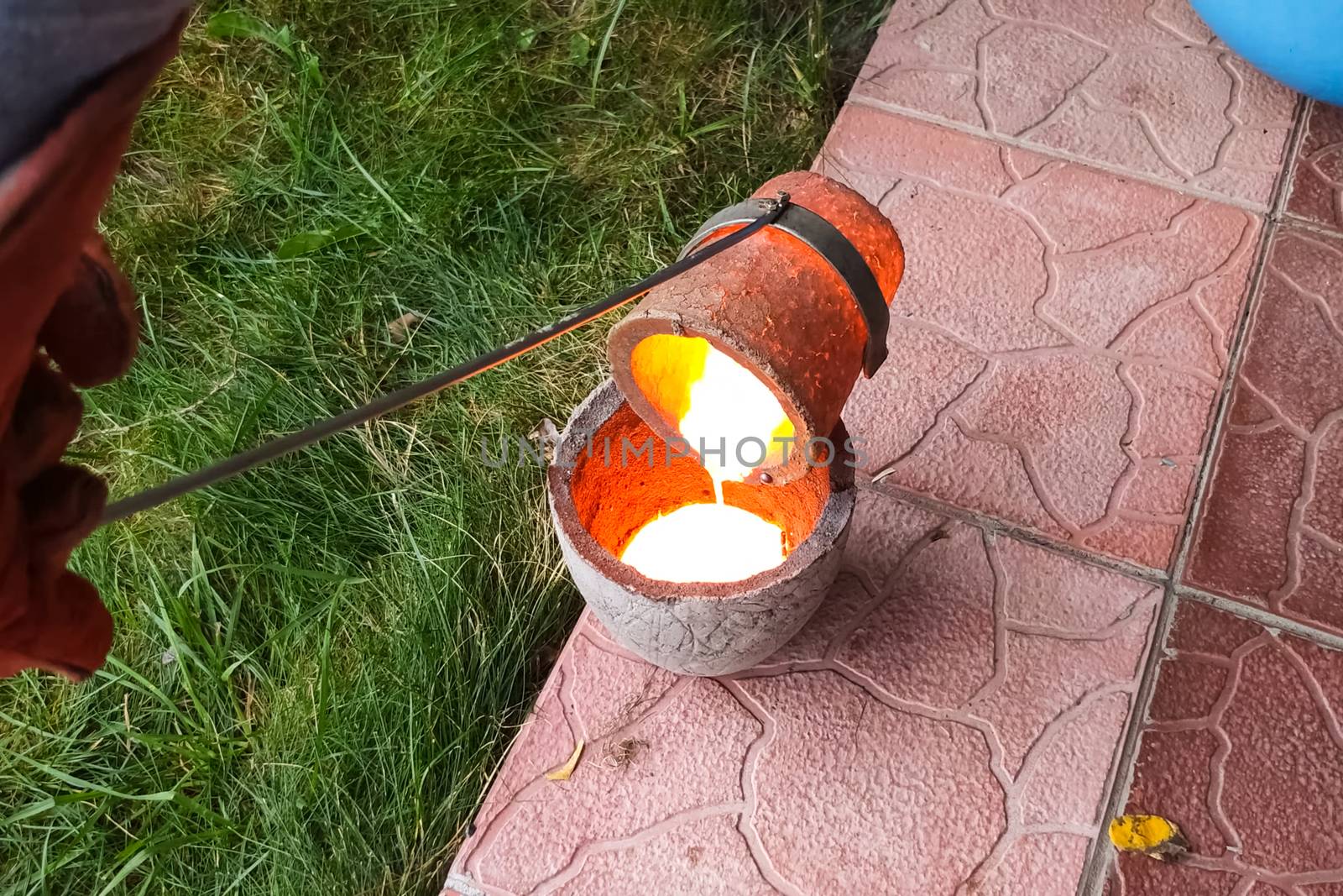 Melted metal in a fireproof cup taken from the oven. Melting copper at home.