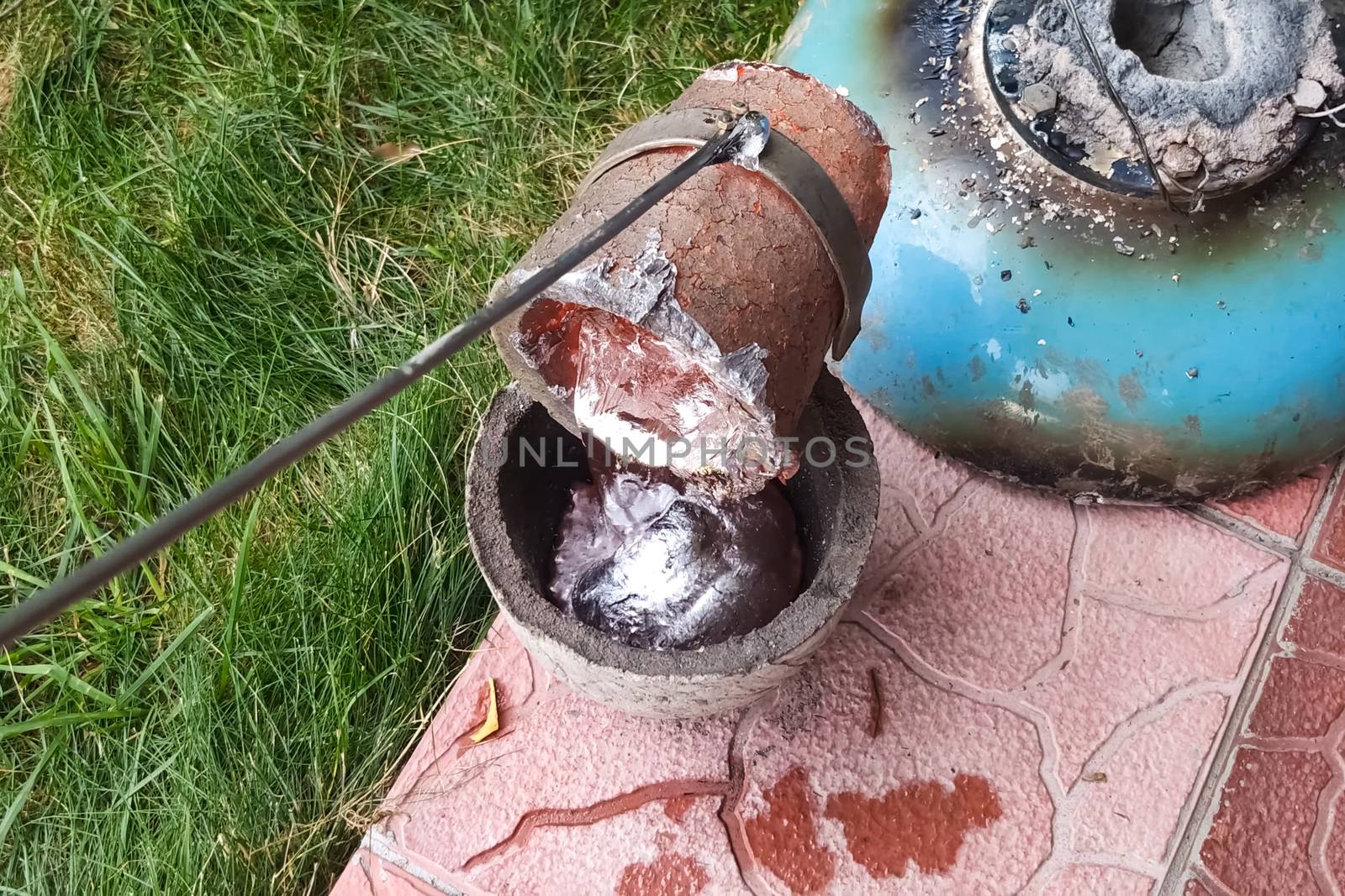 Melted metal in a fireproof cup taken from the oven. Melting copper at home.