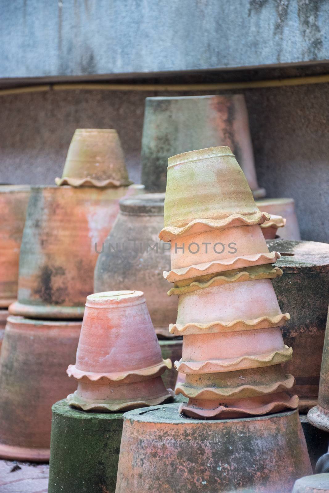 A group of terracotta pots that are stacked in the garden