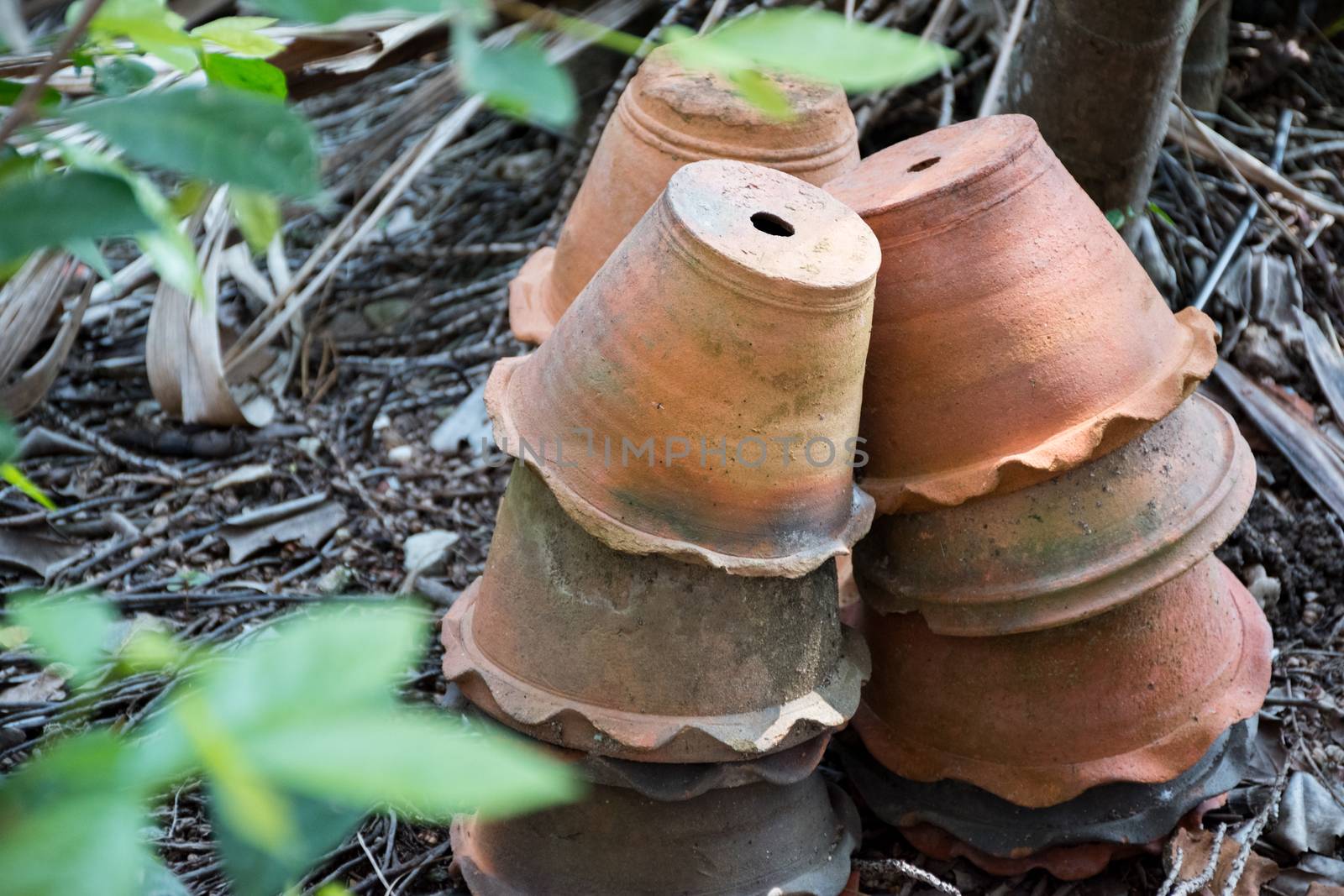 A group of terracotta pots that are stacked in the garden