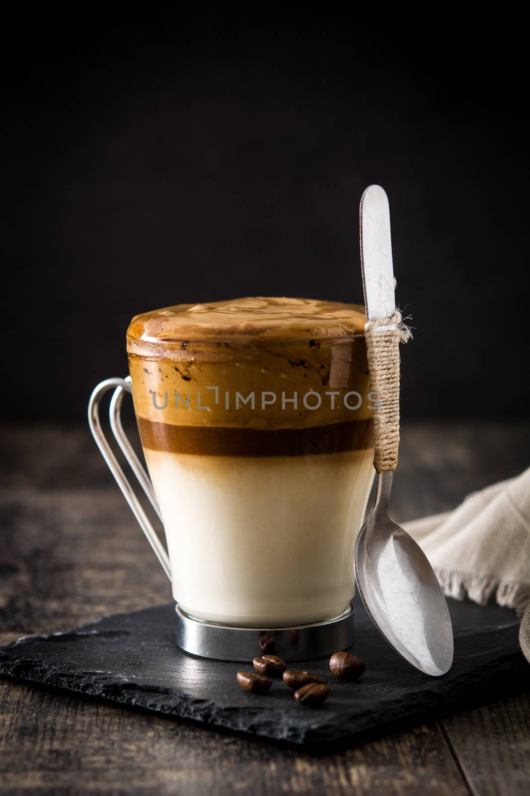 Creamy iced dalgona coffee on wooden table