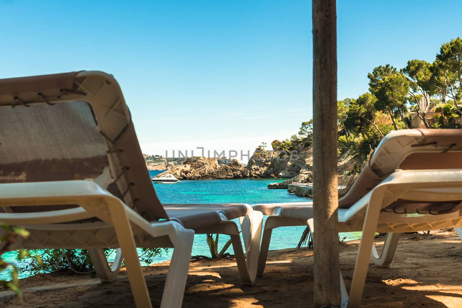 Idyllic sea view from two sun chairs of beautiful bay beach of Cala Fornells on Mallorca island, Mediterranean Sea Spain 