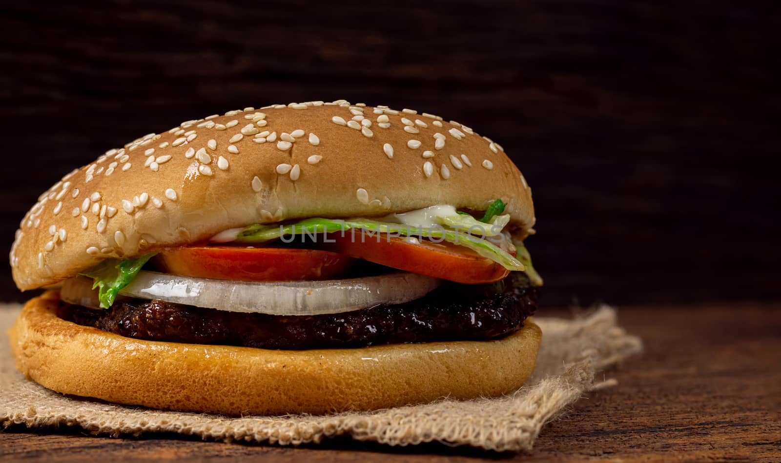 Hamburger meat and vegetables on wooden background by sompongtom