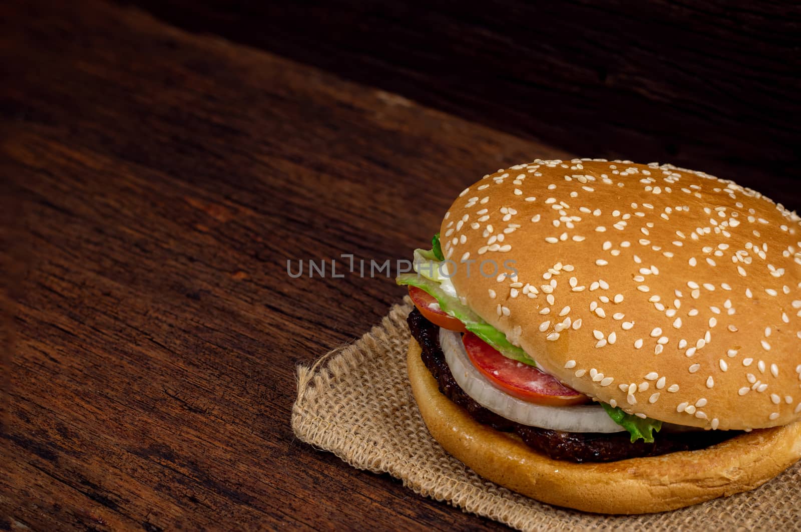 Hamburger meat and vegetables on wooden background by sompongtom