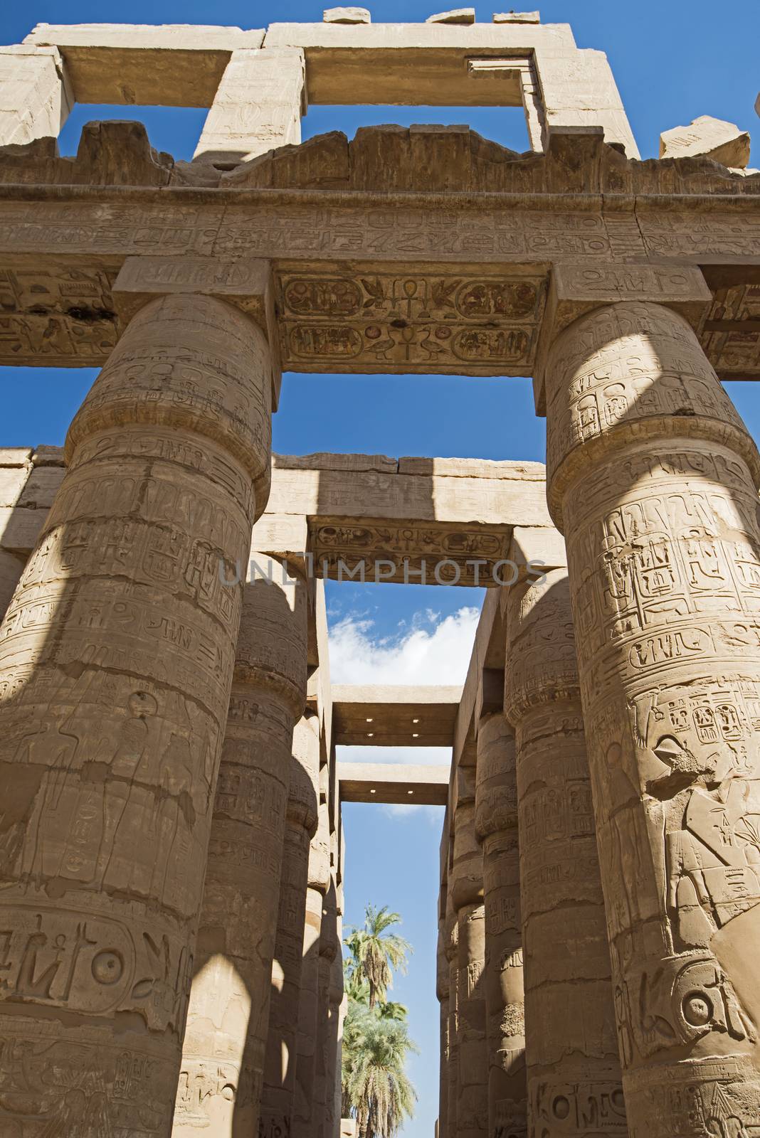 Columns with hieroglyphic carvings and paintings in hypostyle hall at anciant egyptian Karnak Temple in Luxor