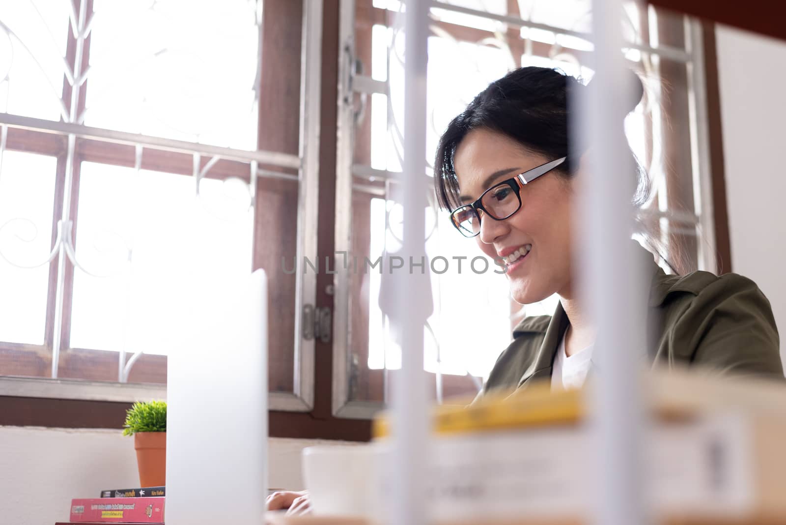 Modern young Asian woman working from home with happy and smile.