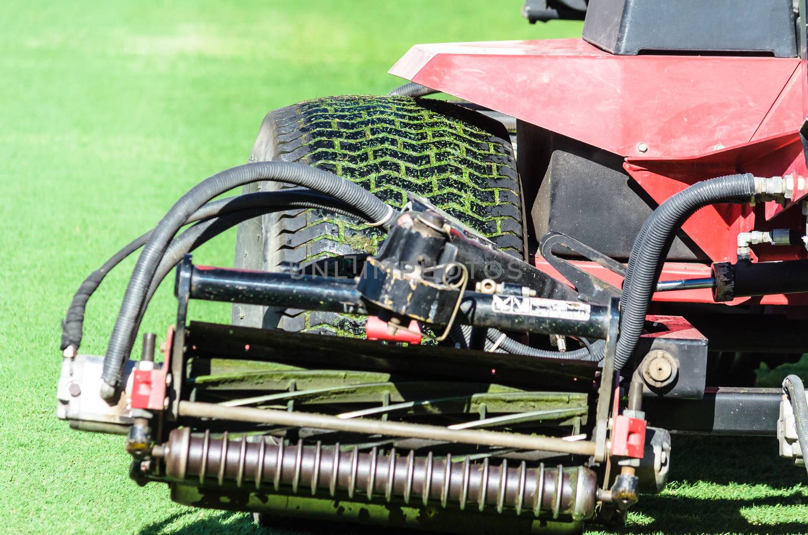 A big wheel of Grass Tractor on the football field.