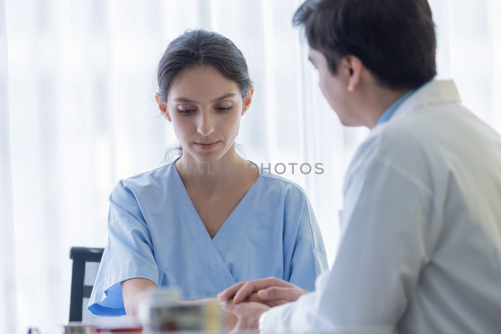 A doctor takes care of a sick patient woman with sadness and unhappiness at the hospital or medical clinic.