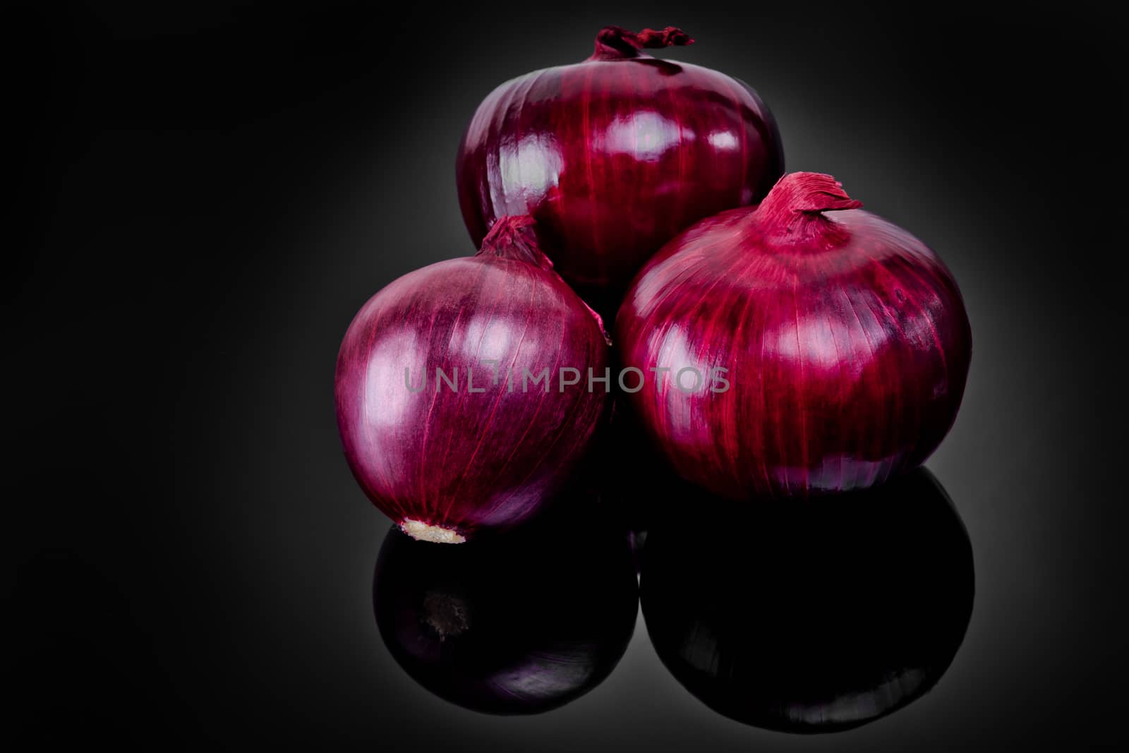 Shallots on black background with reflect onion bulb. by leonik