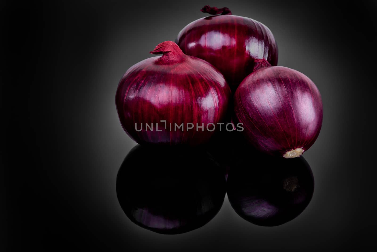 Shallots on black background with reflect onion bulb.