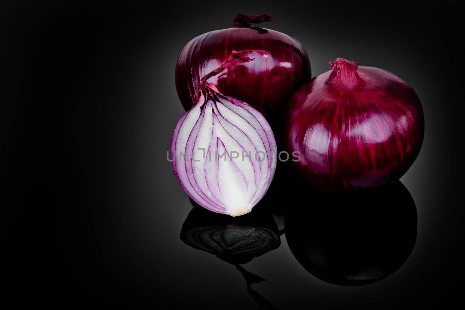 Red onion and half slice on black background with reflect. by leonik