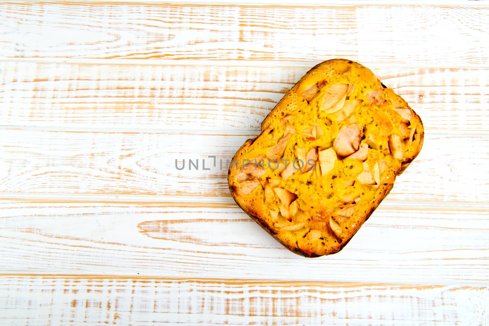 Fresh bakery. Baked pie with apples on white wooden background.