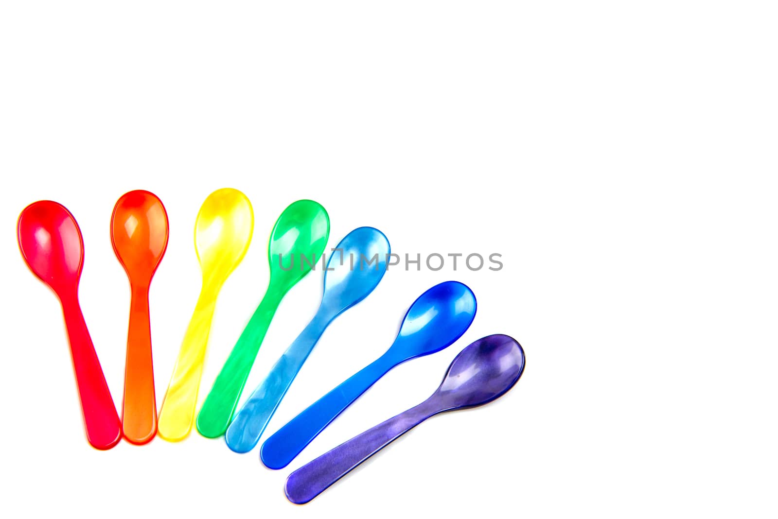 Multicolored spoons isolated on white background.