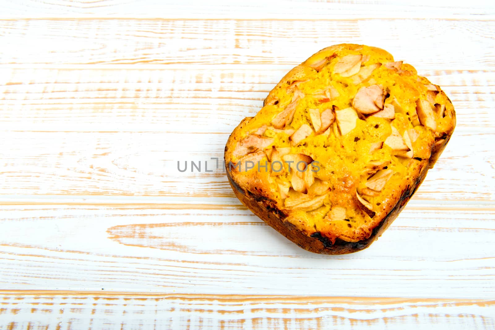 Fresh bakery. Baked pie with apples on white wooden background.